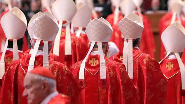 a group of people wearing red robes and hats